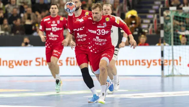 Kroatischer Nationalspieler läuft im roten Trikot mit Ball in der Hand